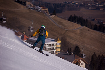 Image showing snowboarder running down the slope and ride free style