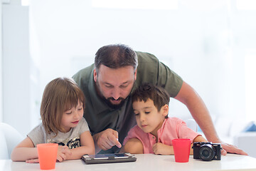 Image showing single father at home with two kids playing games on tablet