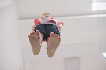 Image showing little boy standing on transparent glass floor