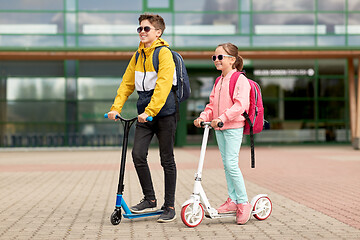 Image showing happy school children with backpacks and scooters