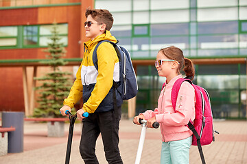 Image showing happy school children with backpacks and scooters