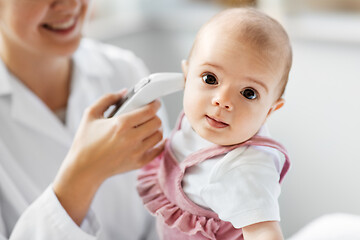 Image showing doctor with thermometer measures baby temperature