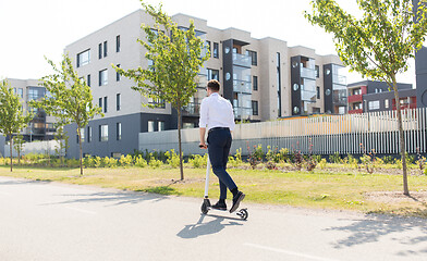 Image showing young businessman riding electric scooter outdoors