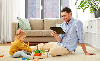 Image showing father with tablet pc and baby daughter at home