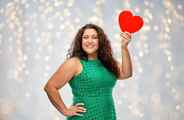 Image showing happy woman holding red heart over lights