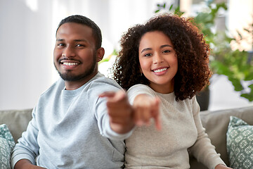 Image showing happy african american couple pointing to camera