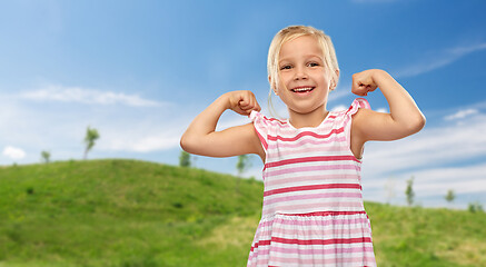 Image showing smiling little girl showing her power in summer