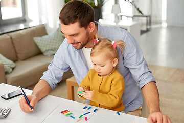 Image showing working father with baby daughter at home office