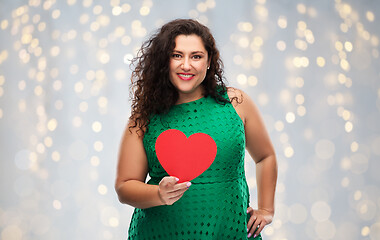 Image showing happy woman holding red heart over lights