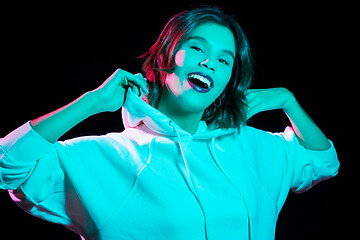 Image showing woman wearing hoodie in neon lights over black