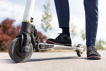 Image showing young businessman with electric scooter outdoors