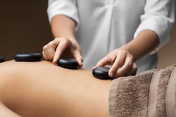 Image showing close up of woman having hot stone massage at spa