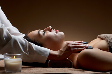 Image showing close up of woman having hot stone massage at spa