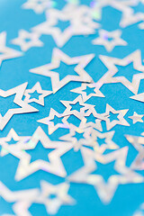 Image showing star shaped confetti decoration on blue background