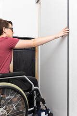 Image showing disabled woman opens a door in her flat