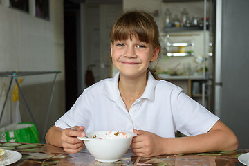 Image showing The girl cheered up after eating soup at lunch