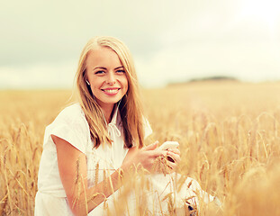 Image showing happy woman with smartphone and earphones