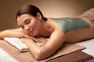 Image showing woman with blue clay mask on her back at spa