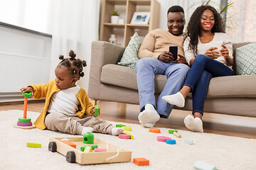 Image showing african baby girl playing with toy blocks at home