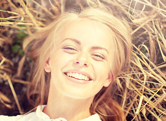 Image showing happy young woman lying on cereal field