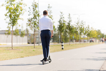 Image showing young businessman riding electric scooter outdoors
