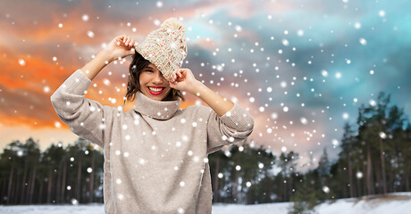 Image showing woman in hat and sweater over winter forest