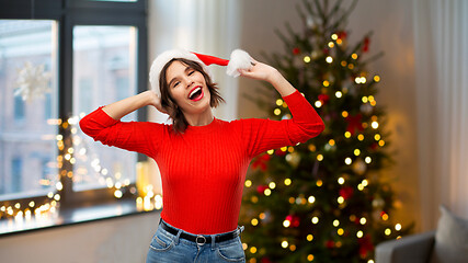 Image showing happy young woman in santa hat on christmas