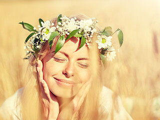 Image showing happy woman in wreath of flowers on cereal field