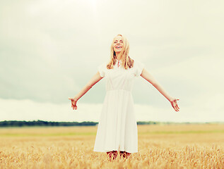 Image showing smiling young woman in white dress on cereal field