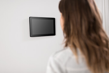 Image showing woman looking at tablet computer at smart home