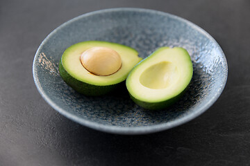 Image showing close up of ripe avocado with bone in ceramic bowl