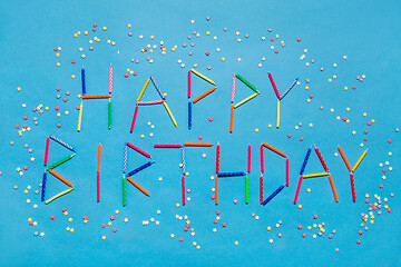 Image showing words happy birthday made of candles on blue