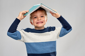 Image showing little boy with roof of book on top of his head