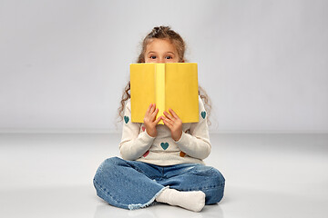 Image showing little girl with book sitting on floor