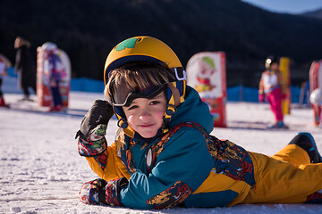 Image showing little snowboarder lying on the snow