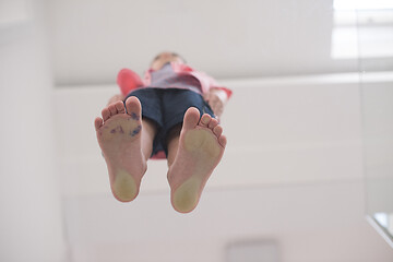 Image showing little boy standing on transparent glass floor