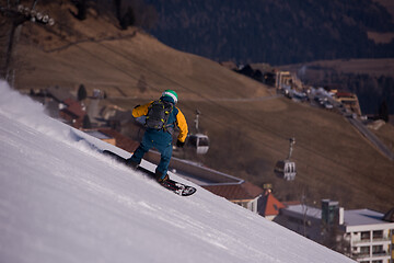 Image showing snowboarder running down the slope and ride free style