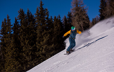 Image showing snowboarder running down the slope and ride free style