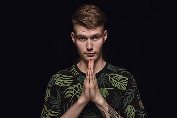 Image showing Close up portrait of young man isolated on black studio background