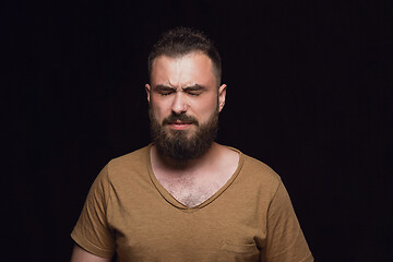 Image showing Close up portrait of young man isolated on black studio background