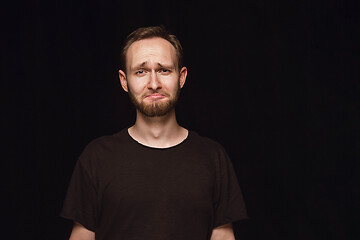 Image showing Close up portrait of young man isolated on black studio background