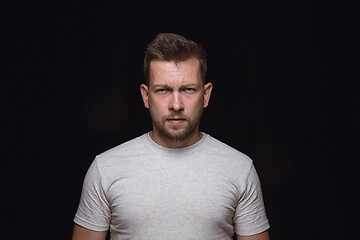 Image showing Close up portrait of young man isolated on black studio background