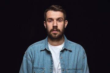 Image showing Close up portrait of young man isolated on black studio background