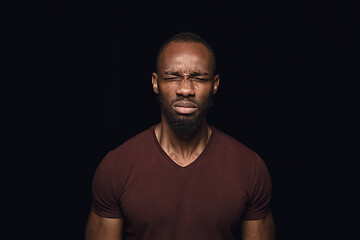 Image showing Close up portrait of young man isolated on black studio background