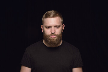 Image showing Close up portrait of young man isolated on black studio background