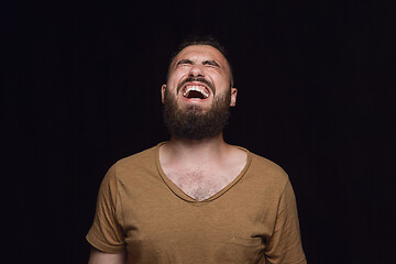 Image showing Close up portrait of young man isolated on black studio background