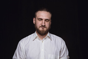 Image showing Close up portrait of young man isolated on black studio background