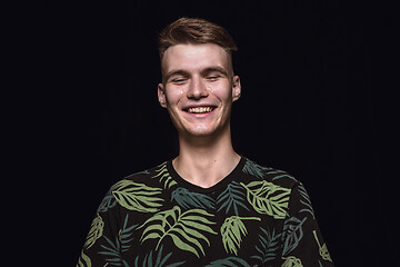 Image showing Close up portrait of young man isolated on black studio background