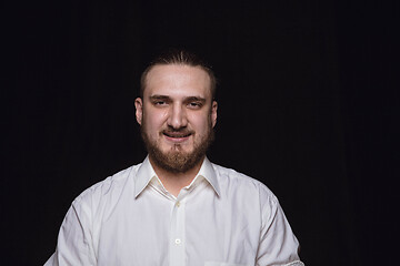 Image showing Close up portrait of young man isolated on black studio background