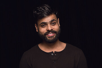 Image showing Close up portrait of young man isolated on black studio background